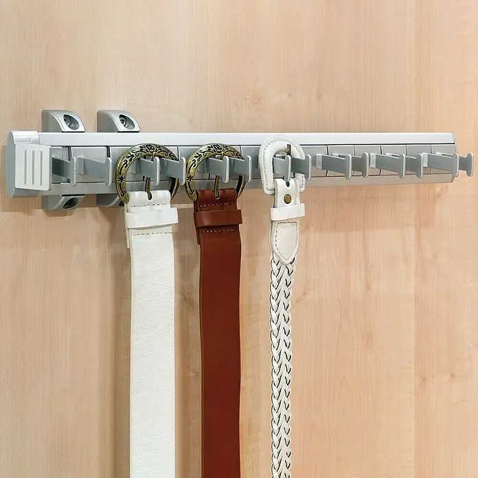 Emuca Mantelhaken Ausziehbar - L x B x H: 44,7 x 8,5 x 8 cm, Silber, Aluminium - Wandmontierter Gürtelhalter aus grauem Kunststoff mit drei hängenden Gürteln in Weiß und Braun.