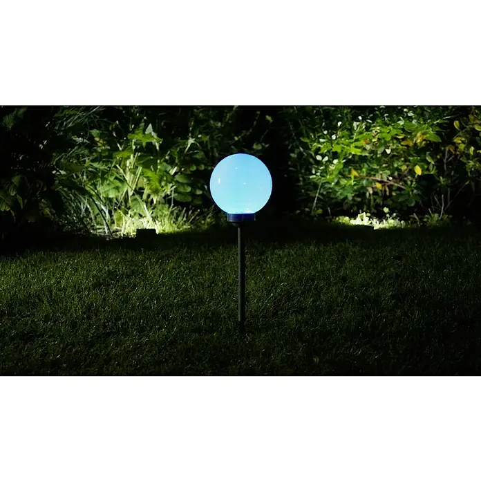 BAUHAUS Solar-Dekoleuchte Ball - Höhe: 525 mm, IP44 - Ein Garten mit einem kugelförmigen Solarlicht, das ein beruhigendes blaues Licht ausstrahlt, eingebettet in üppiges Grün für einen Hauch von Eleganz im Freien.