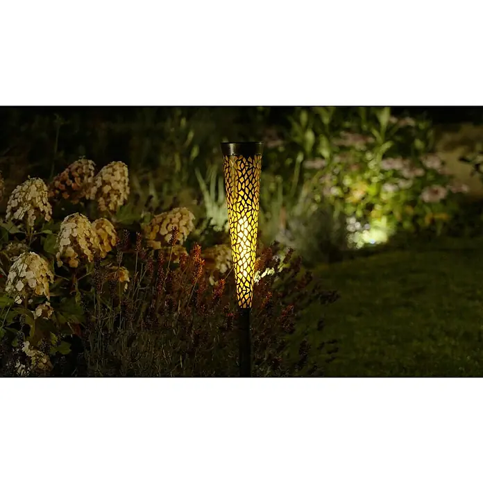 BAUHAUS Solar-Dekoleuchte - Schwarz/Silber, IP44 - Nachts im Garten leuchtet eine dekorative Solarleuchte mit auffälligem Muster, die eine warme Atmosphäre erzeugt.