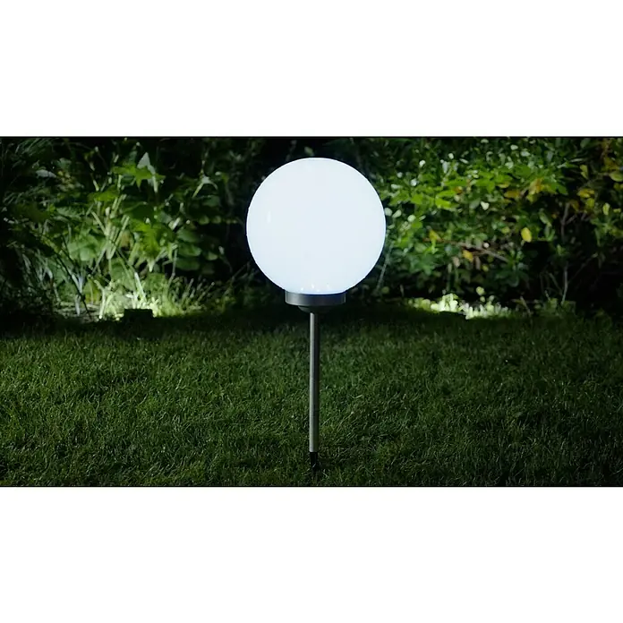 BAUHAUS Solar-Kugelleuchte FaraErdspieß, Durchmesser: 30 cm, Höhe: 73 cm, LED, 8 h - Elegante Gartenleuchte: Eine kugelförmige Lampe mit hellem Licht erhellt den Rasen und die umliegende Vegetation.