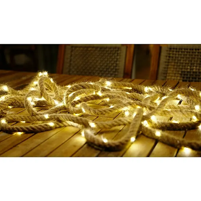 BAUHAUS Solar-Lichterkette - Länge: 13 m, LED - Nahaufnahme einer dekorativen Seil-Lichterkette auf einem Holztisch, ideal für stimmungsvolle Beleuchtung und rustikale Dekoration.