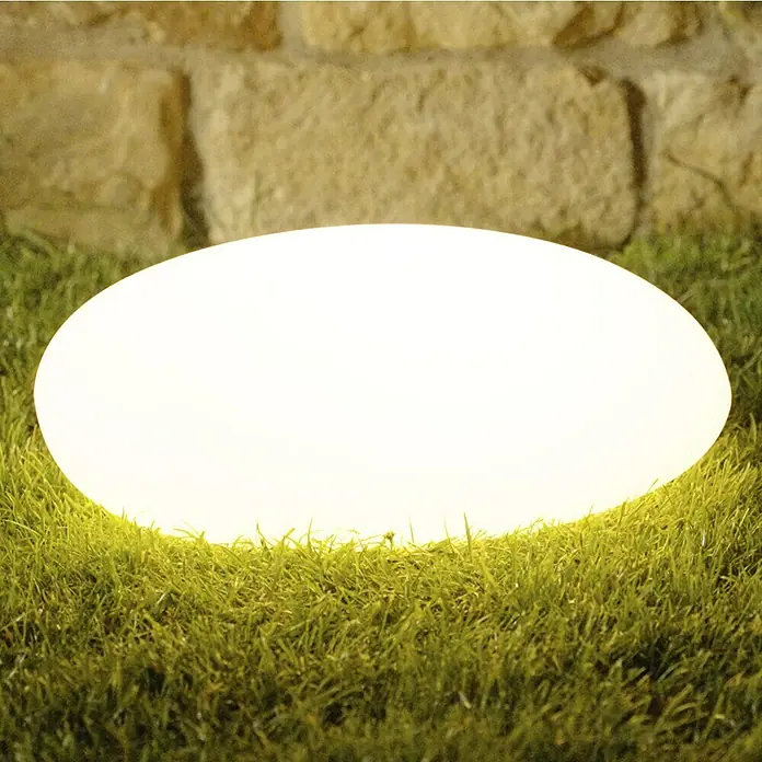Solar-Dekoleuchte - Weiß, L x B x H: 36 x 50 x 19,5 cm - Ein leuchtender ovaler Gartenstein strahlt warmes Licht auf das grüne Gras. Der dekorative Stein sorgt für eine stimmungsvolle Atmosphäre im Freien.