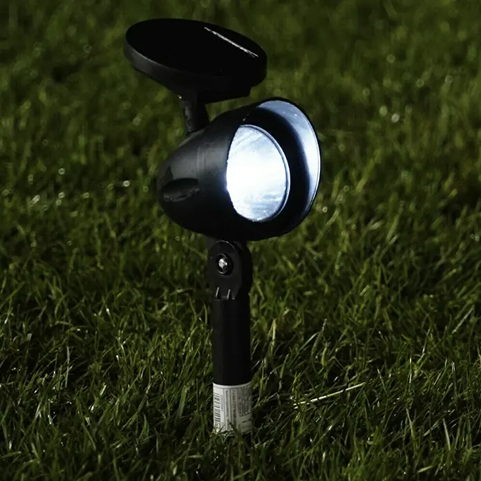 BAUHAUS Solar-Spot 2 - 0,18 W, Schwarz, IP44, 4 lm - Bild einer Solar-Gartenleuchte auf einem Rasen. Die Lampe hat ein Solarpanel und leuchtet hell.