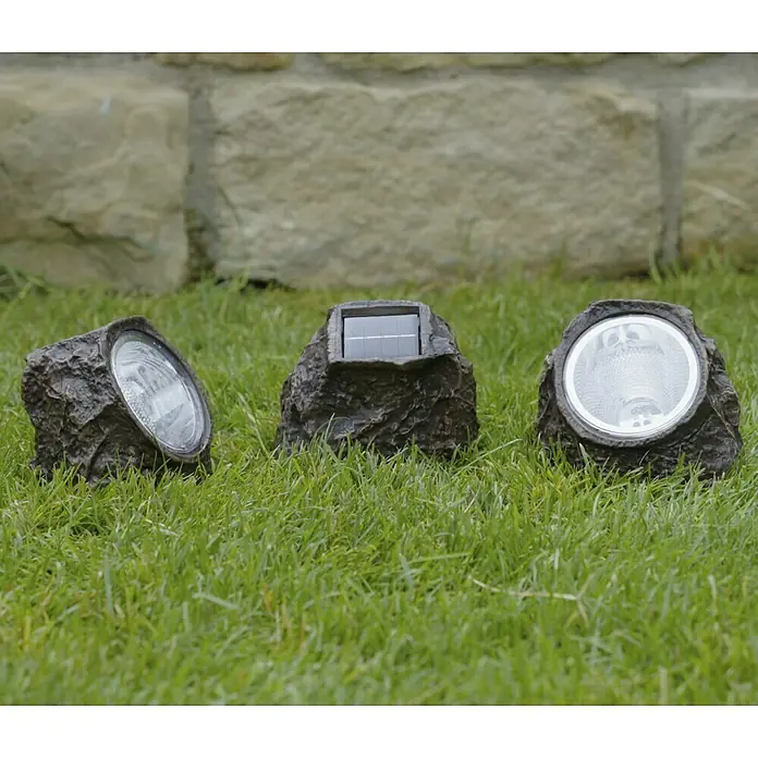 BAUHAUS Solarstein Rock - LED - Drei Stein-Solarstrahler im Gras, die eine natürliche Gartenbeleuchtungslösung bieten.