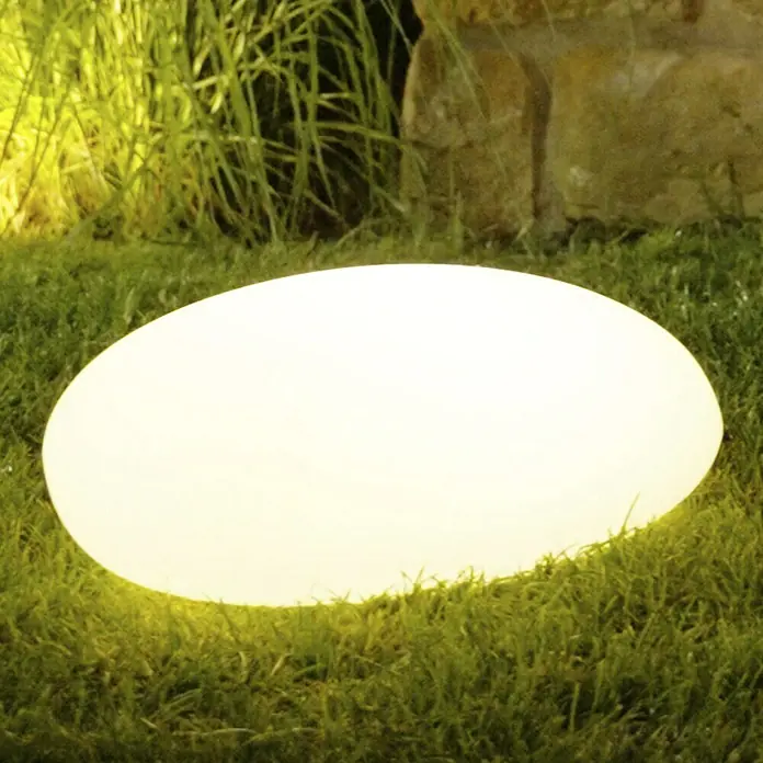 LED-SolarsteinWeiß, L x B x H: 30 x 40 x 16 cm - Nahaufnahme eines leuchtenden LED-Gartensteins auf Rasen, der eine moderne und stimmungsvolle Außenbeleuchtung bietet.\n