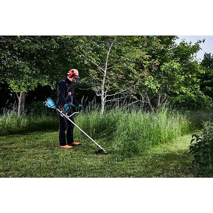 Makita LXT 18V Akku-Freischneider DUR369AZX6 - 18 V, Ohne Akku, Schnittbreite Faden: 43 cm, Schnittbreite Messer: 25,5 cm - Professioneller Landschaftsgärtner mäht mit einer Akku-Motorsense das Gras in einem grünen Park.