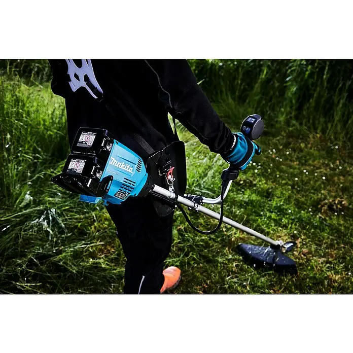 Makita LXT 18V Akku-Freischneider DUR369AZX6 - 18 V, Ohne Akku, Schnittbreite Faden: 43 cm, Schnittbreite Messer: 25,5 cm - Nahaufnahme eines Akku-Rasentrimmers von Makita mit zwei Akkus, der von einer Person im Freien bedient wird.