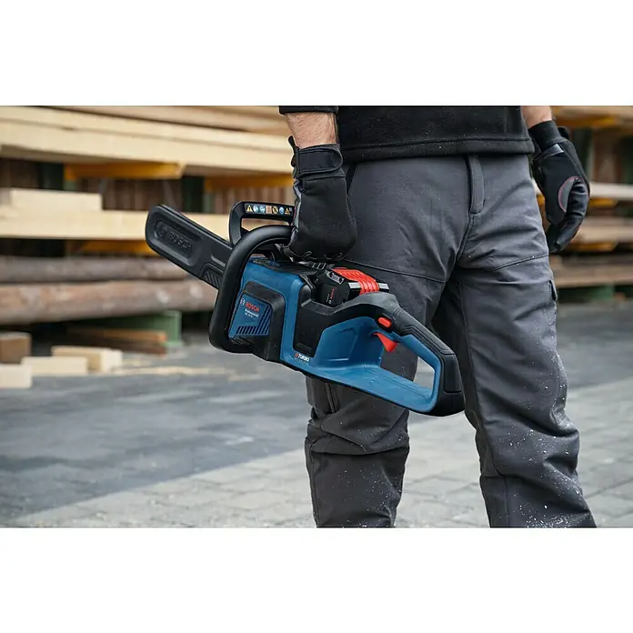 Bosch Professional AMPShare 18V Akku-Kettensäge GKE 18V-40 - 18 V, Li-Ionen, Ohne Akku, Schwertlänge: 40 cm - Mann hält eine Akku-Kettensäge von Bosch, Modell AdvancedShear, in der Hand, vor einem Hintergrund aus Holz. Ideal für Gartenarbeiten.