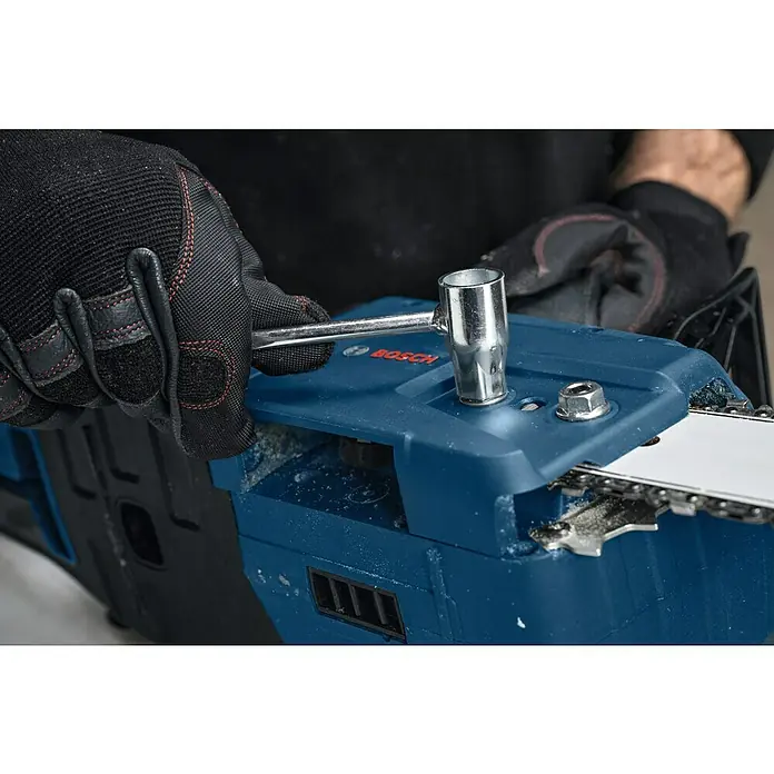 Bosch Professional AMPShare 18V Akku-Kettensäge GKE 18V-40 - 18 V, Li-Ionen, Ohne Akku, Schwertlänge: 40 cm - Ein Akkuschrauber von Bosch wird mit einem Steckschlüssel und einer Ratsche eingestellt. Der Schrauber ist blau und schwarz, die Werkzeuge silber.