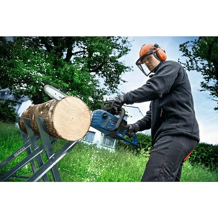 Bosch Professional AMPShare 18V Akku-Kettensäge GKE 18V-40 - 18 V, Li-Ionen, Ohne Akku, Schwertlänge: 40 cm - Ein Mann sägt mit einer Bosch Akku-Kettensäge ein Holzscheit, geschützt mit Helm und Visier.