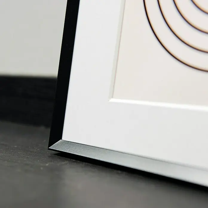 Collagerahmen Pixel - Anzahl Fotoplatzhalter: 11 Stk., Schwarz, Aluminium - Nahaufnahme eines gerahmten Kunstwerks mit einem markanten schwarzen und weißen Rahmen, der die moderne Ästhetik hervorhebt.