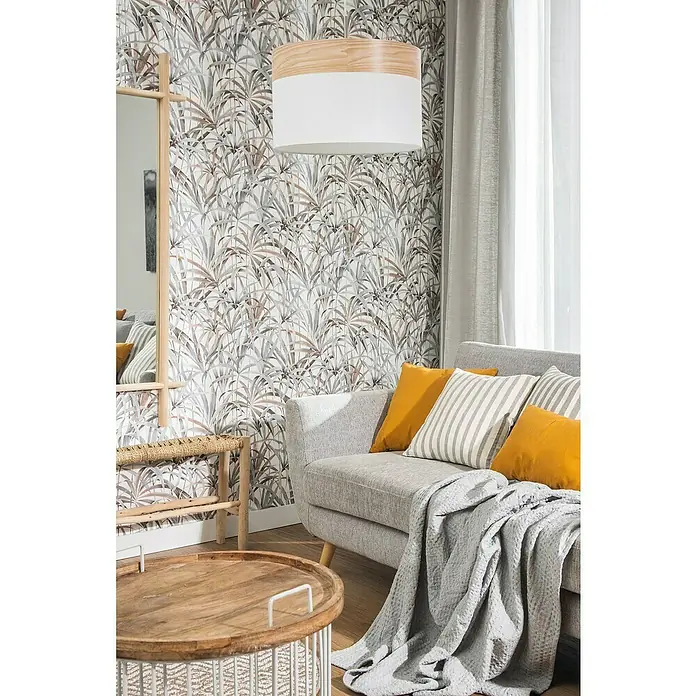 Papel pintado Vegetal con Hojas - Granate, Motivo decorativo, 10 x 0,53 m - Interior luminoso con sofá gris, cojines amarillos y una mesa redonda con tapa de madera, complementado con una lámpara colgante elegante.