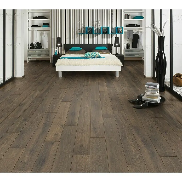 LOGOCLIC Vinto Laminat Classic - Eiche Cocoa, Landhausdiele, 1.288 x 195 x 8 mm - Ein Schlafzimmer mit Holzböden, einem großen Bett mit Flauschendecke und hellen Regalen, die den Raum auf beiden Seiten umrahmen.