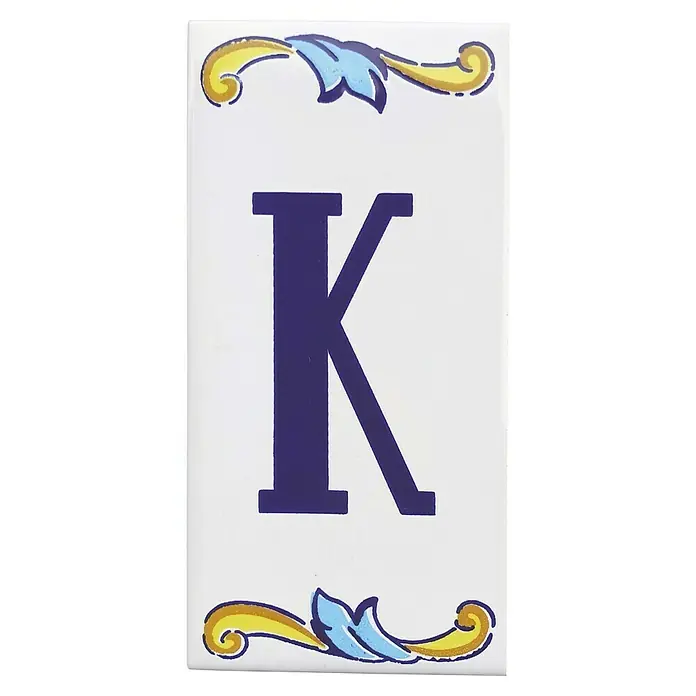 Pavimento cerámico Letra K - 7,5 x 15 cm, Blanco/Azul/Amarillo, Brillante - Baldosa de cerámica con la letra K y detalles florales azules y dorados, ideal para una decoración de pared elegante.