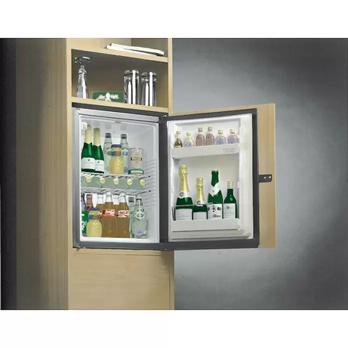 Suki Bisagra de plástico - L x An: 149 x 25 mm, Marrón - Una nevera minibar abierta, integrada en un mueble de madera clara, provista de varias botellas y latas.