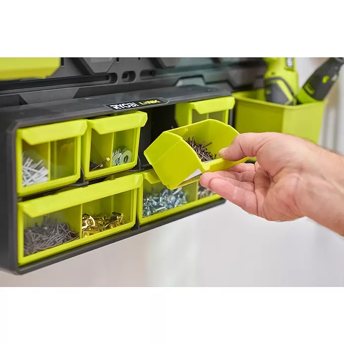 Ryobi Link Sortimentskasten RSLW 309 - Anzahl Fächer: 6 Stk. - Hand entnimmt Nägel aus leuchtend grünem Behälter eines schwarzen RYOBI LINK Modul-Organizers mit Kleinteilen.