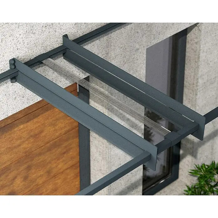 Palram – Canopia Pultvordach Nancy - 452 x 94 x 14 cm, Anthrazitgrau - Nahaufnahme einer modernen Vordachkonstruktion mit Glasdach und grauem Metallrahmen über einer Holztür.