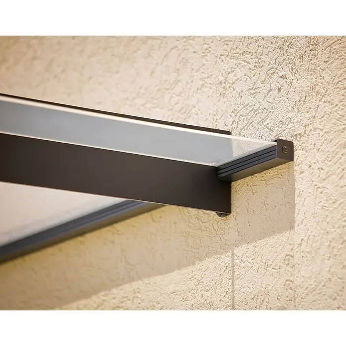 Palram – Canopia Marquesina para puerta Nancy - 411 x 94 x 14 cm, Gris antracita - Vista detallada de un toldo de vidrio moderno con marco oscuro, montado en una pared texturizada de color claro.