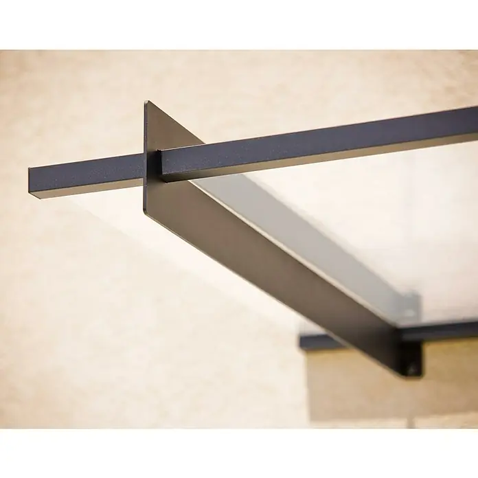 Palram – Canopia Marquesina para puerta Nancy - 411 x 94 x 14 cm, Gris antracita - Primer plano de un moderno toldo de vidrio con soportes de metal oscuro, montado en una pared de color claro. El diseño elegante ofrece un atractivo llamativo.