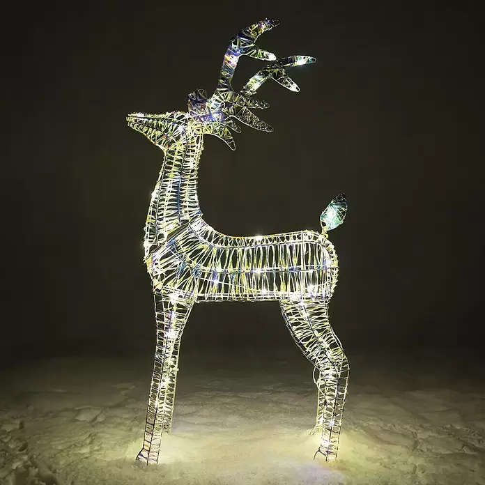 LED-Weihnachtsdekofigur Hirsch Bling - 22 x 60 x 100 cm, Klar/Irisierend, Netzbetrieben, LED - Eine schillernde beleuchtete Rentierdekoration mit bunten Lichtern, die im Dunkeln auf Schnee steht.