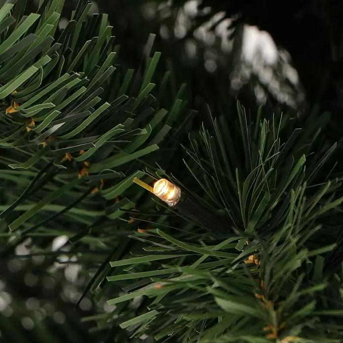 Künstlicher Weihnachtsbaum Joy - Höhe: 90 cm, Grün, LED-Beleuchtung - Nahaufnahme von künstlichen grünen Tannennadeln mit einer warmweißen LED-Leuchte.