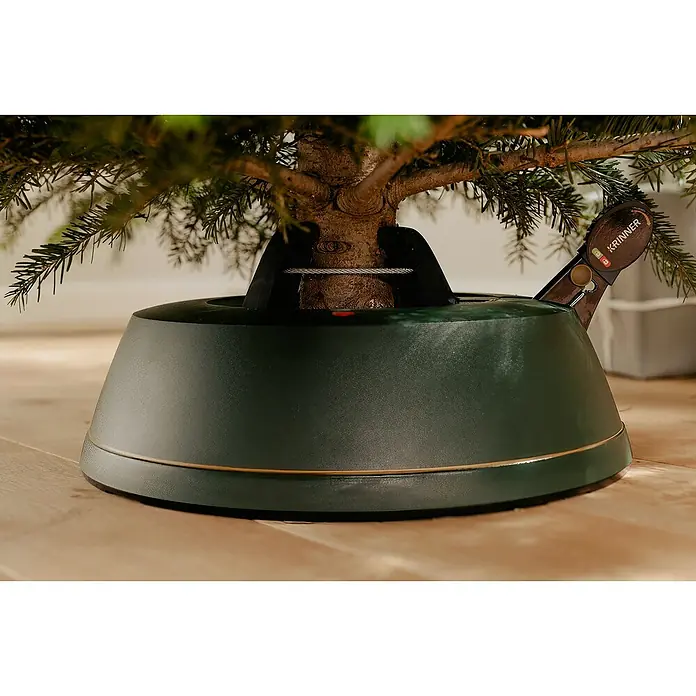 Krinner Christbaumständer Best Choice L - Rund - Nahaufnahme eines Krinner Weihnachtsbaumständers mit Baum, der auf einem hellen Holzboden steht.