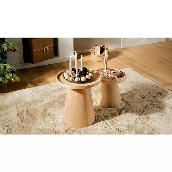 Adventskerzenhalter magnetisch - Schwarz - Zwei helle Beistelltische aus Holz auf einem flauschigen Teppich. Ein Tisch trägt einen beleuchteten Adventskranz, der andere eine Holz-Nussknackerfigur und Farben.
