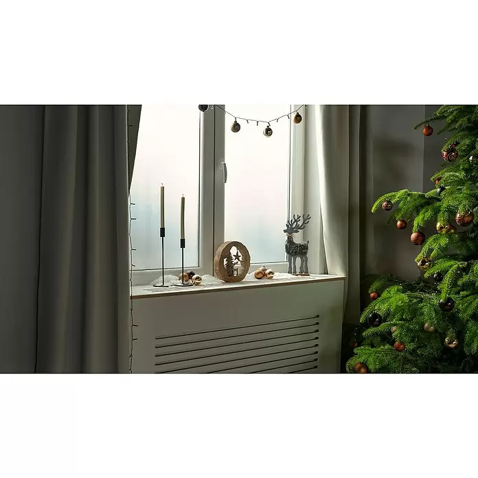 Dekoelement Hirsch & Tanne - L x B x H: 23 x 5 x 23 cm, Braun, Silber, Holz - Ein festlich geschmücktes Fensterbrett mit brennenden Kerzen, Hirschfiguren und goldenen Kugeln, neben einem Weihnachtsbaum mit Gold- und Bronzeornamenten.