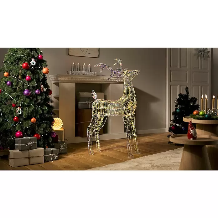 LED-Weihnachtsdekofigur Hirsch Bling - 22 x 60 x 100 cm, Klar/Irisierend, Netzbetrieben, LED - Leuchtende schillernde Rentier-Dekoration mit LEDs, steht in festlichem Wohnzimmer.