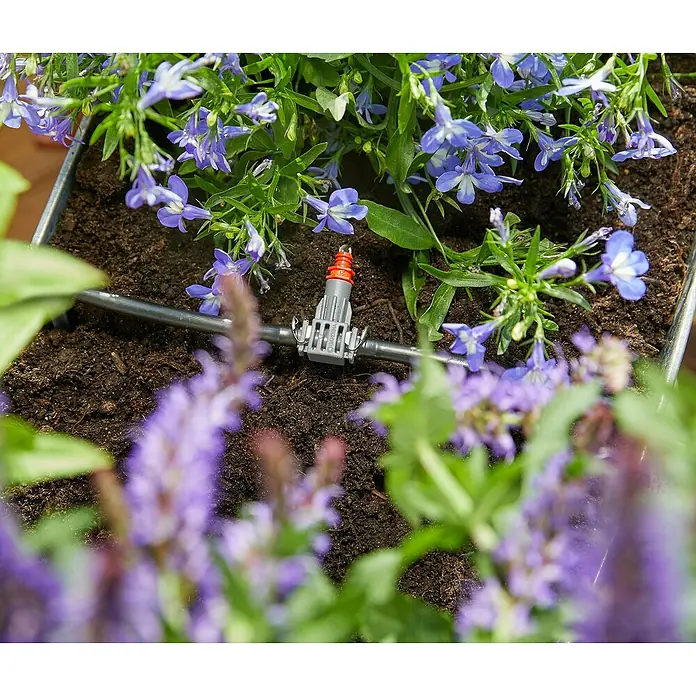 Gardena Micro-Drip Blumenkasten-Bewässerungs-SetEinsatzbereich: Bewässerungstechnik - Nahaufnahme eines Gardena Micro-Drip-Systems in einem Blumenkasten, umgeben von blühenden Pflanzen für eine effiziente Bewässerung.