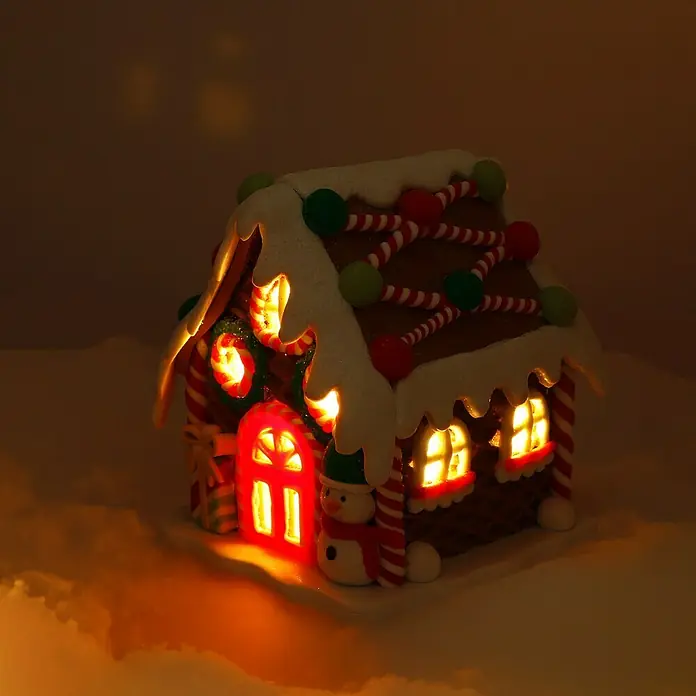 LED-Weihnachtsdekoleuchte Lebkuchenhaus - 12 x 14 x 12 cm, Mehrfarbig, Batteriebetrieben, LED - Detailansicht eines leuchtenden Lebkuchenhauses mit Süßigkeiten und Schnee verziert, das eine festliche, warme Atmosphäre erzeugt.