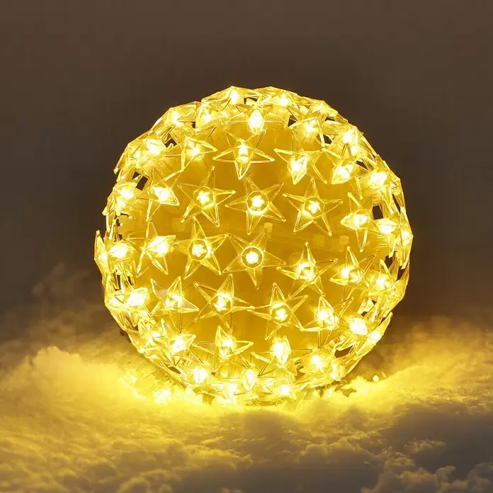 Tween Light LED-Weihnachtsdekoleuchte Sterne - Weiß, Netzbetrieben, LED, 13 cm - Warmgelbe LED-Kugel aus klaren Sternenlichtern, hell leuchtend auf einer Schneefläche.