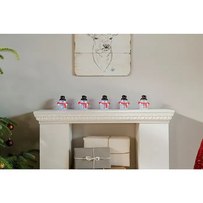 Tween Light LED-Lichterkette Schneemann - Innen, Lichtfarbe: Warmweiß, Anzahl Leuchtmittel: 40 Stk., Batteriebetrieben - Eine festliche Szene mit leuchtenden Schneemännern auf einem Kaminsims, die eine warme, weihnachtliche Atmosphäre verbreiten.