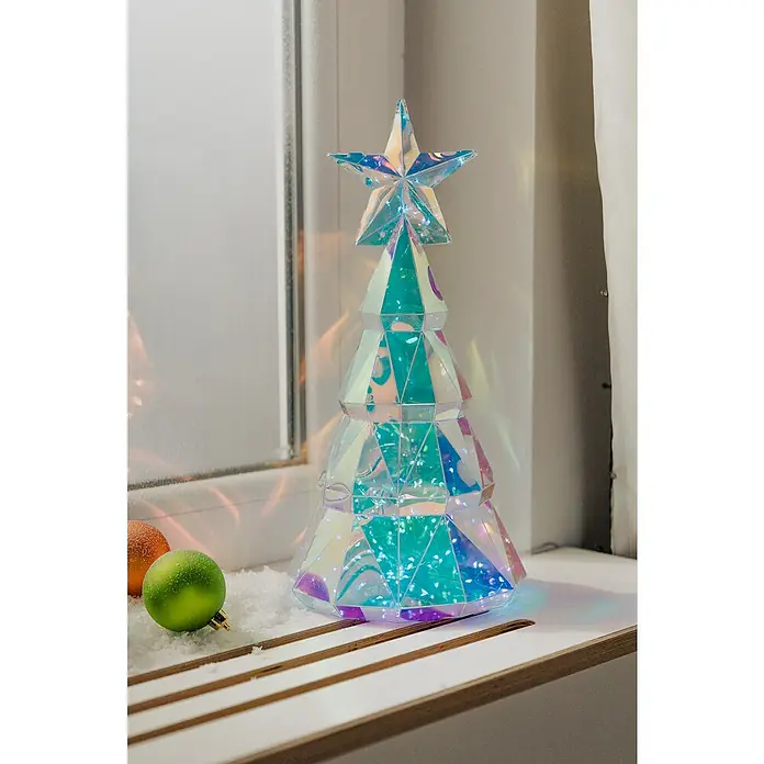 Tween Light Lámpara LED decorativa con caja de regalo - Multicolor, L x An x Al: 19 x 19 x 38 cm, Árbol - Figura decorativa de árbol de Navidad hecha de material iridiscente con una estrella en la parte superior, rodeada de nieve artificial y bolas.