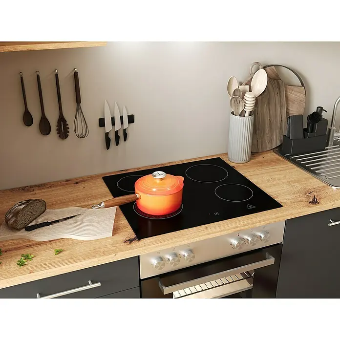 Respekta Inselküche Hilde Typ 2 - Breite: 280 cm, Grau, Mit Elektrogeräten - Küchenszene mit Kochfeld, orangefarbenem Topf, Brot und Messer. Praktische Küchenhelfer für den Alltag.