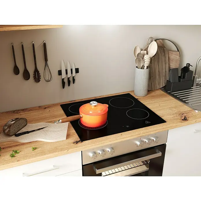 Respekta Inselküche Hilde Typ 2 - Breite: 310 cm, Weiß, Mit Elektrogeräten - Küchenszene mit Kochfeld, Topf und Brotschneidebrett. Die Küchenutensilien sind griffbereit an der Wand platziert.