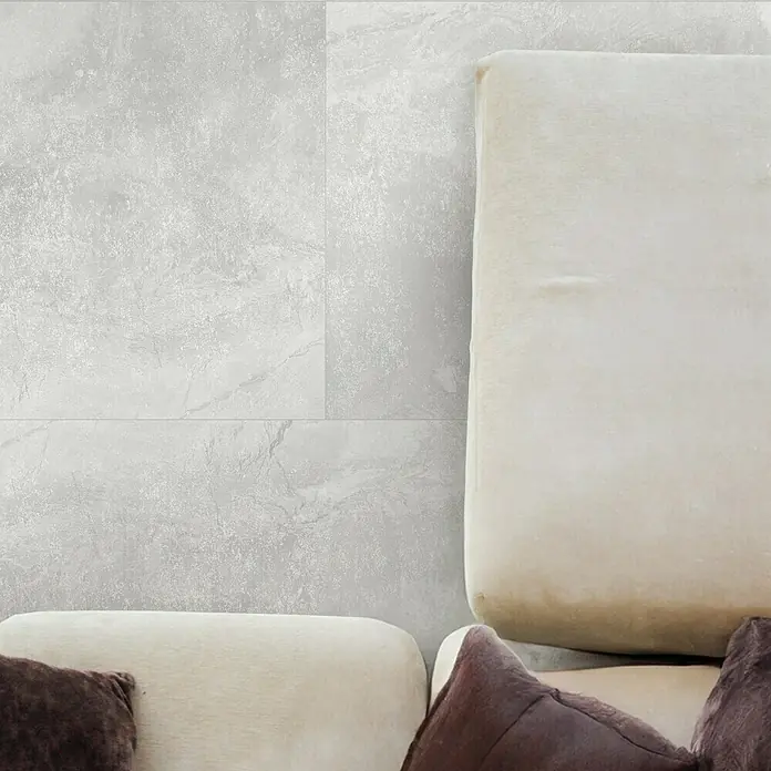Feinsteinzeugfliese Geo White - 60 x 60 cm, Weiß, Schimmernd - Graue Bodenfliesen mit Marmormuster und cremefarbenes Sofa mit braunen Kissen für stilvolles Interieur.