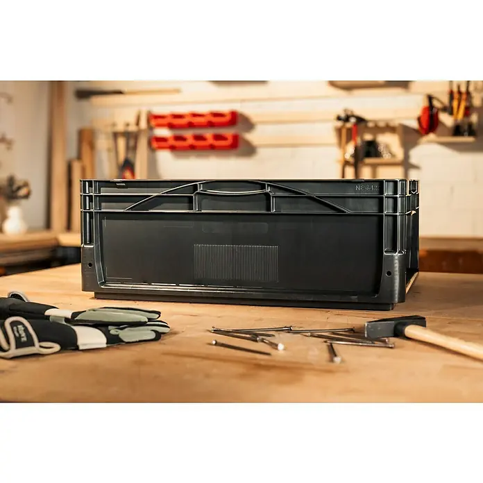 BAUHAUS Eurobox - L x B x H: 60 x 40 x 22 cm, 44 l, Schwarz - Ein schwarzer Kunststoffbehälter steht auf einem Tisch neben Werkzeugen. Perfekt zur Aufbewahrung von Werkzeugen und Materialien in der Werkstatt.