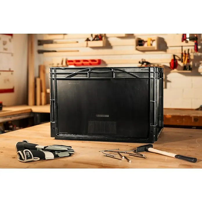 BAUHAUS Eurobox - L x B x H: 60 x 40 x 40 cm, 76 l, Schwarz - Aufnahme eines schwarzen Kunststoffbehälters, der auf einem Holztisch in einer Werkstatt steht, umgeben von Werkzeugen.