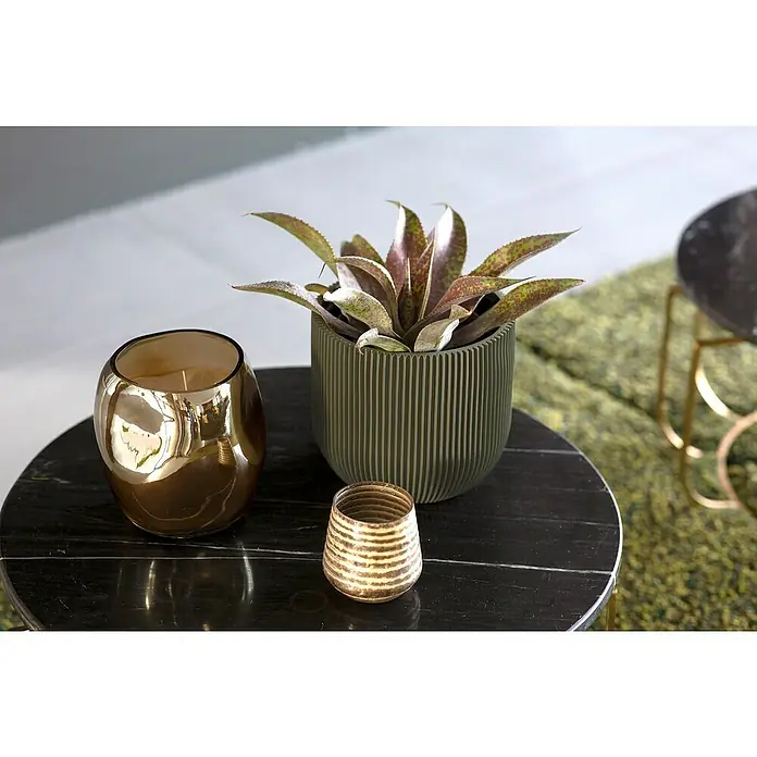 Capi Europe Übertopf rund Nature Groove - Außenmaß (Ø x H): 24 x 21 cm, Grün, Polyester - Dekoratives Stillleben mit einer Duftkerze in Gold, einer gestreiften Vase und einer Zimmerpflanze in einem gerillten Topf auf einem Tisch.