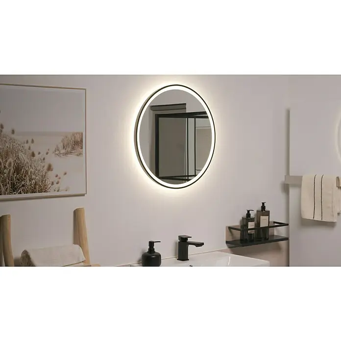 DSK Lichtspiegel Desire - Durchmesser: 55 cm, Schwarz, Leuchtmittel - Ein beleuchteter runder Badezimmerspiegel mit einem modernen schwarzen Rahmen, der über einem stilvollen Waschbecken mit Armaturen und einer Ablage hängt.