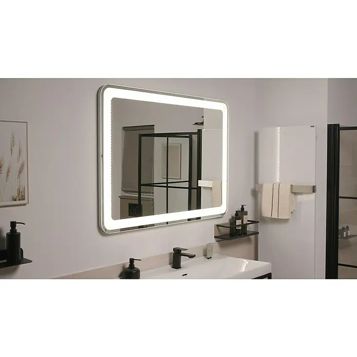 Camargue Stella Lichtspiegel - 120 x 84 cm, Mit abgerundeten Kanten - Ein quadratischer LED-Badezimmerspiegel mit abgerundeten Ecken hängt über einem modernen Waschbecken mit schwarzen Armaturen und Seifenspendern.