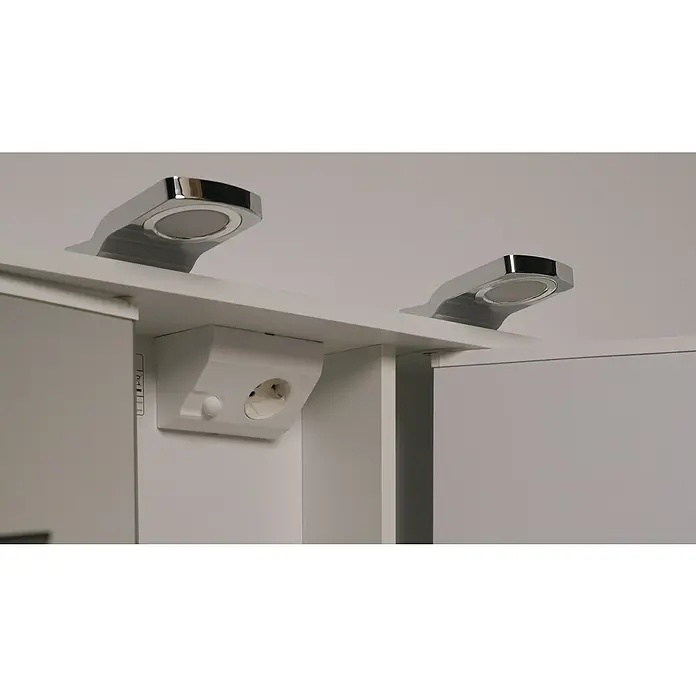 Jokey LED-Spiegelschrank Lena - B x H: 80 x 64 cm, Holz, Weiß - Nahaufnahme von zwei modernen, verchromten LED-Leuchten unter einem weißen Schrank mit einer integrierten Steckdose.