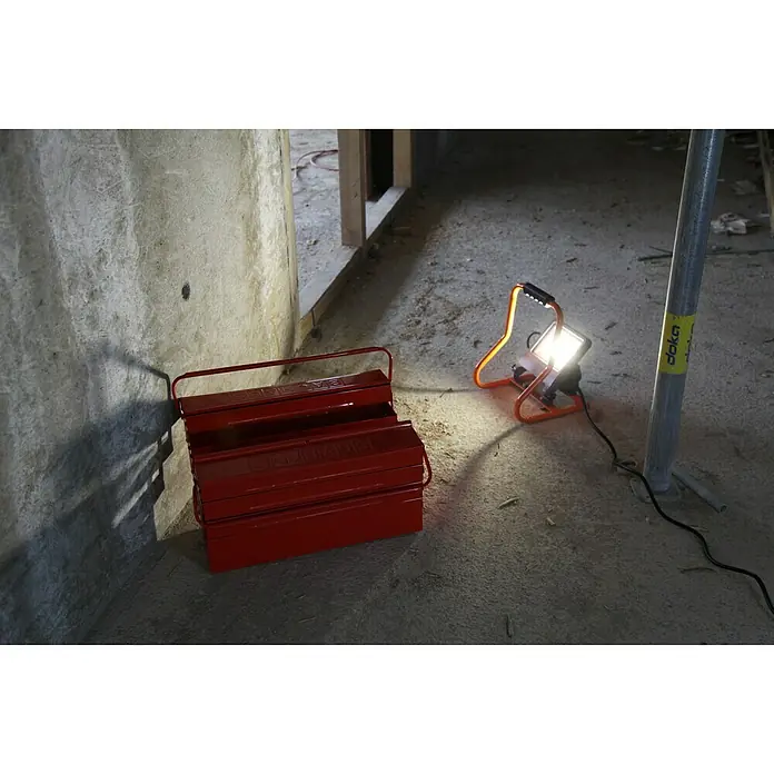 Ledvance LED-Strahler - 30 W, 2.700 lm, 4.000 K, L x B x H: 19 x 22 x 29 cm, IP44 - Rote Werkzeugkiste und Baustellenlampe in einem unfertigen Raum.