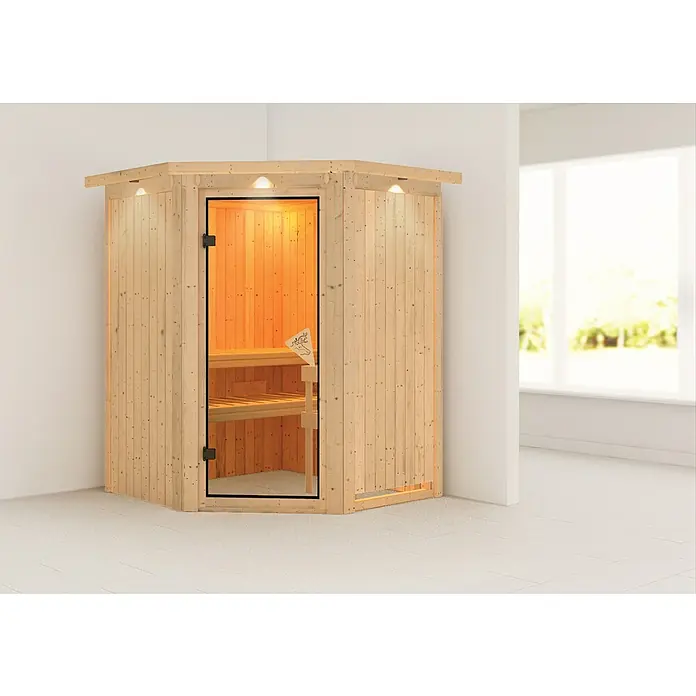 Karibu Elementsauna Larin - Ohne Ofen, Mit Dachkranz und Beleuchtung, L x B x H: 165 x 165 x 192 cm - Elegante Ecksauna mit Glasfront und Holzverkleidung in einem hellen Raum. Die Sauna bietet Entspannung und ein stilvolles Ambiente für Ihr Zuhause.