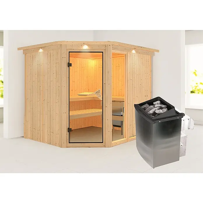 Karibu Elementsauna Fiona - Mit 9 kW Ofen mit integrierter Steuerung, Mit Dachkranz und Beleuchtung, L x B x H: 245 x 210 x 192 cm - Eine helle, hölzerne Ecksauna mit Glasfront und ein Saunaofen mit Steinen im Vordergrund.