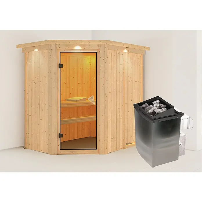Karibu Elementsauna Carin - Mit 9 kW Ofen mit integrierter Steuerung, Mit Dachkranz und Beleuchtung, L x B x H: 165 x 210 x 192 cm - Das Bild zeigt eine Sauna mit Holzwänden, einer Glastür und einem Saunaofen mit Steinen, der für die Hitze in der Sauna sorgt.