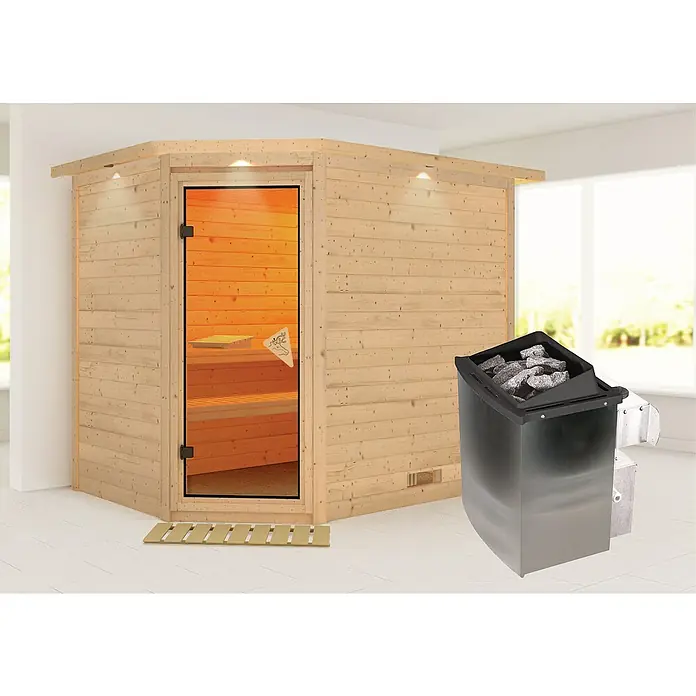 Karibu Massivholzsauna Tanami - Mit 9 kW Ofen mit integrierter Steuerung, Mit Dachkranz und Beleuchtung, L x B x H: 259 x 210 x 192 cm - Das Bild zeigt eine moderne Sauna mit Holzwänden, einer Glastür und einem Saunaofen mit Steinen. Die Sauna strahlt Wärme und Entspannung aus.