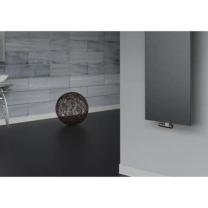 Szagato Designheizkörper Manhattan 2 - B x H: 470 x 1.200 mm, Wärmeleistung bei Vorlauftemperatur von 75 °C (D: 50): 799 W, Moonstone-Grau, Ohne Handtuchhalter - Eine Nahaufnahme eines modernen, vertikalen Heizkörpers in dunkler Farbe, der an einer hellgrauen Wand montiert ist. Er ist minimalistisch gestaltet.