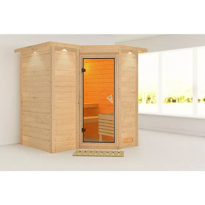Karibu Massivholzsauna Sahib 1 - Ohne Ofen, Mit Dachkranz und Beleuchtung, L x B x H: 221 x 198 x 198 cm - Das Bild zeigt eine freistehende Holzsauna mit einer Glastür, die einen Blick auf die Holzbänke im Inneren ermöglicht. Sie steht auf einem Fliesenboden.